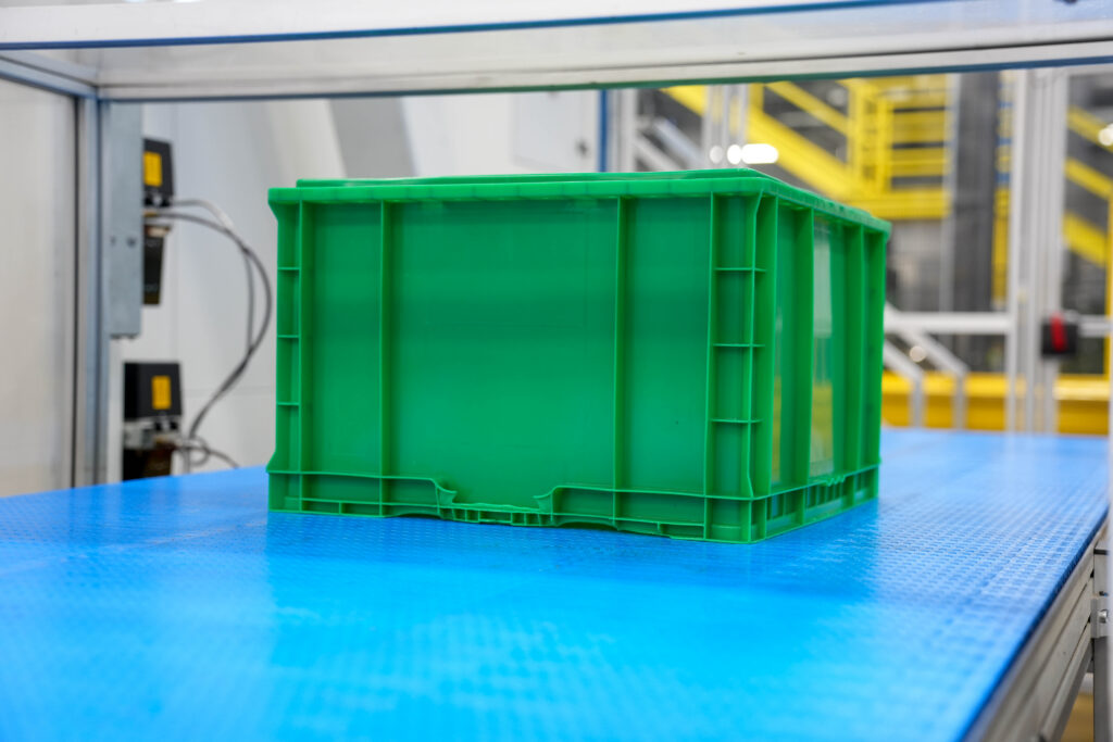 Straight-wall container being manufactured in a warehouse.