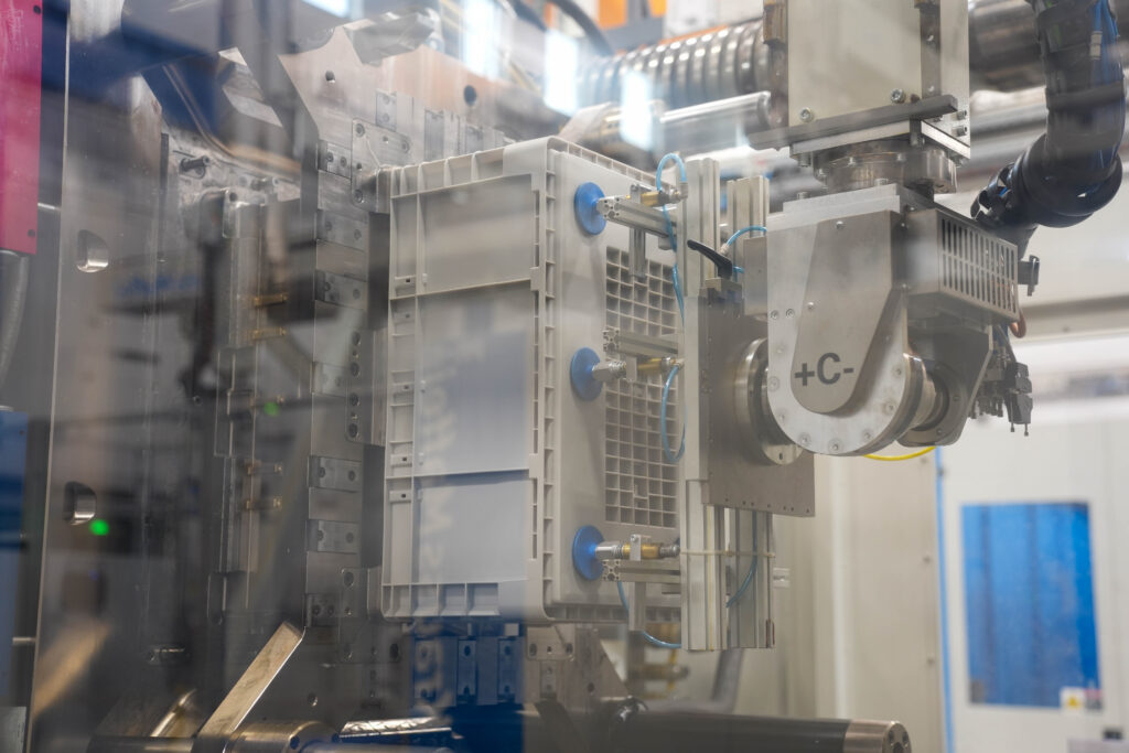 Automation container being taken out of injected molded machine.