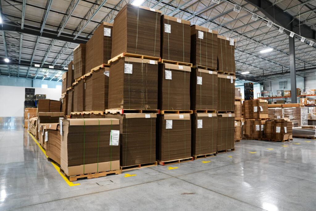 Corrugated cardboard boxes stacked up on a warehouse floor.